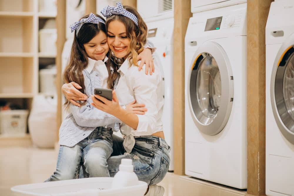 mother with daughter doing laundry self serviece laundrette min