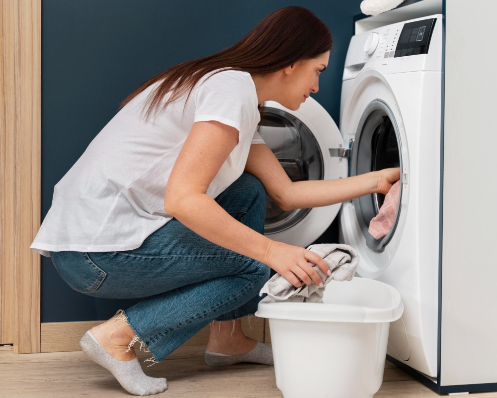 woman putting dirty clothes washing machine